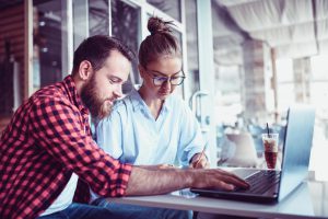 Couple Writing Sports Bet Tickets In Coffee Bar With Internet Prognosis